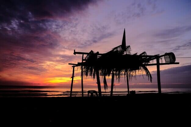 beach-scene-with-hut-foreground-sunset-background_803639-1569